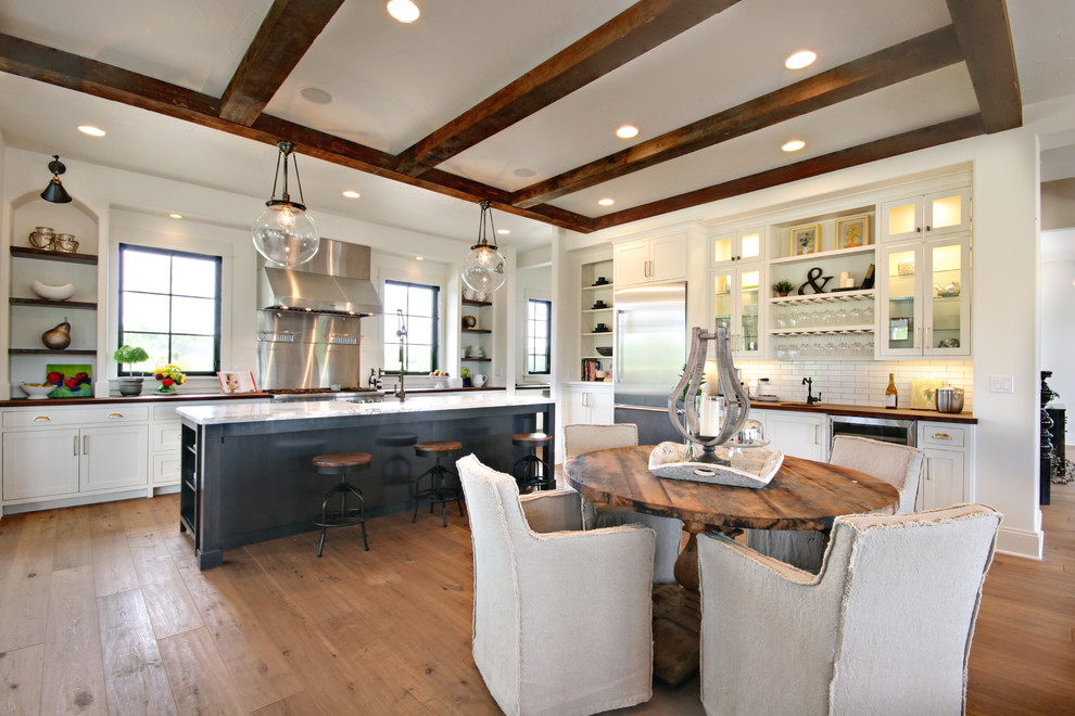 This is an example of a rural kitchen/dining room in Grand Rapids with white walls and light hardwood flooring.