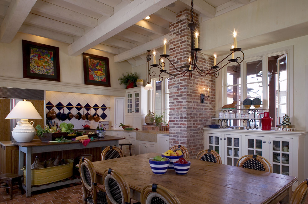 Foto di una grande sala da pranzo aperta verso la cucina tropicale con pareti beige e pavimento in terracotta