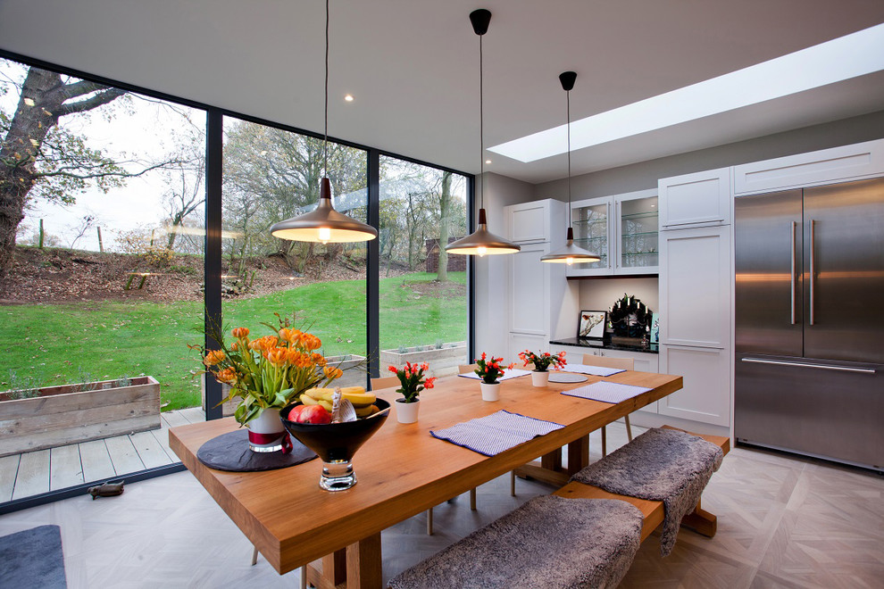 Idee per una sala da pranzo aperta verso la cucina contemporanea di medie dimensioni con pareti bianche e pavimento in legno massello medio