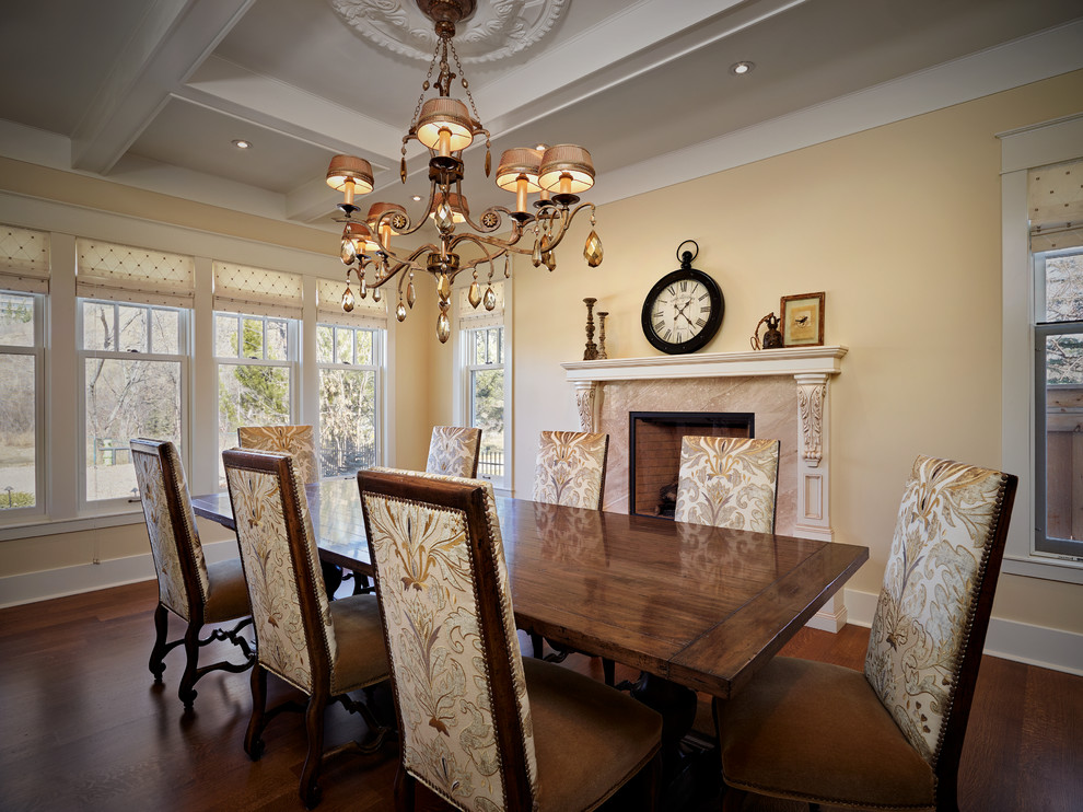Inspiration for a large victorian enclosed dining room in Calgary with yellow walls, medium hardwood flooring, a standard fireplace and a stone fireplace surround.