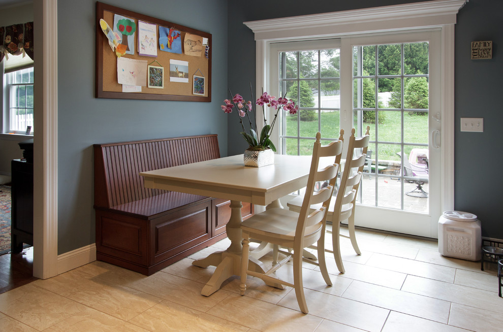 Cette image montre une salle à manger ouverte sur la cuisine rustique de taille moyenne avec un mur bleu, un sol en carrelage de porcelaine et un sol beige.