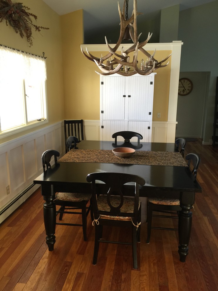 Esempio di una sala da pranzo american style di medie dimensioni con pareti gialle e pavimento in legno massello medio