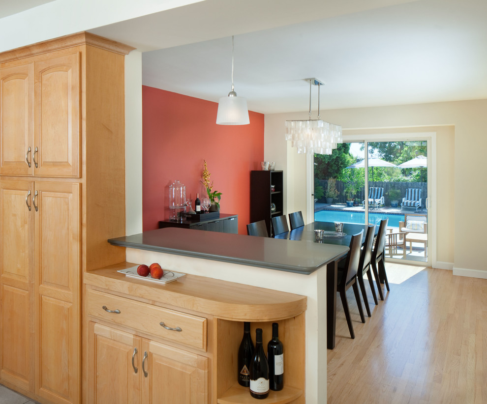 Ispirazione per una sala da pranzo aperta verso la cucina minimalista di medie dimensioni con pareti arancioni, parquet chiaro e nessun camino