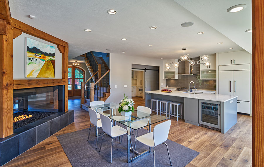 Источник вдохновения для домашнего уюта: большая кухня-столовая в стиле модернизм с разноцветными стенами, паркетным полом среднего тона, двусторонним камином, фасадом камина из дерева и коричневым полом