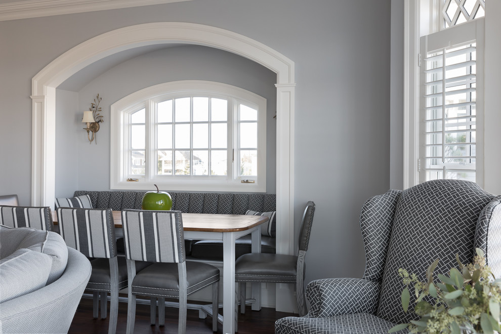 Источник вдохновения для домашнего уюта: большая кухня-столовая в классическом стиле с серыми стенами, коричневым полом, темным паркетным полом, стандартным камином и фасадом камина из дерева