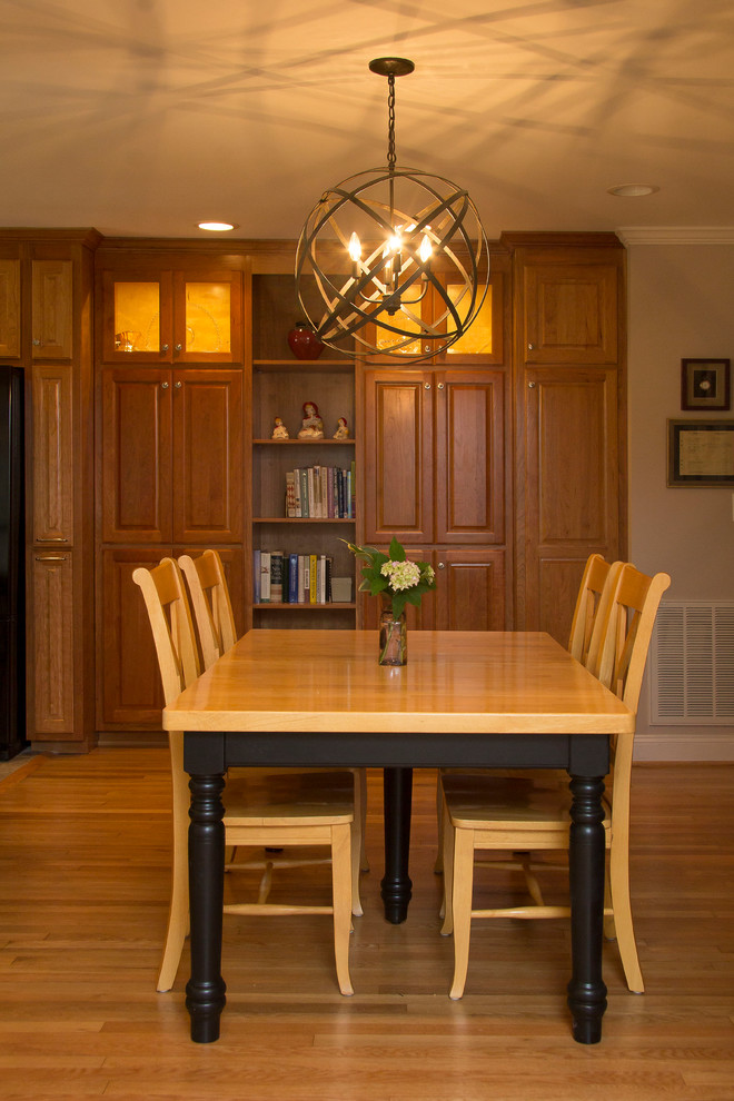 Cette photo montre une salle à manger ouverte sur la cuisine chic de taille moyenne avec un mur beige, un sol en bois brun et un sol orange.