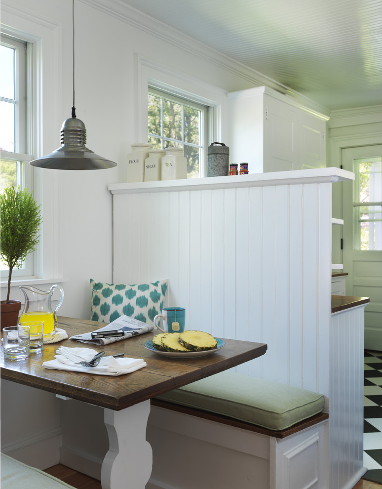 Immagine di una sala da pranzo aperta verso la cucina stile marinaro con pareti bianche