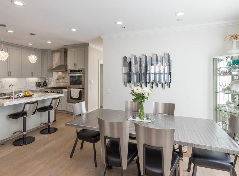 Cette photo montre une salle à manger ouverte sur la cuisine tendance de taille moyenne avec un mur blanc, parquet clair et un sol beige.
