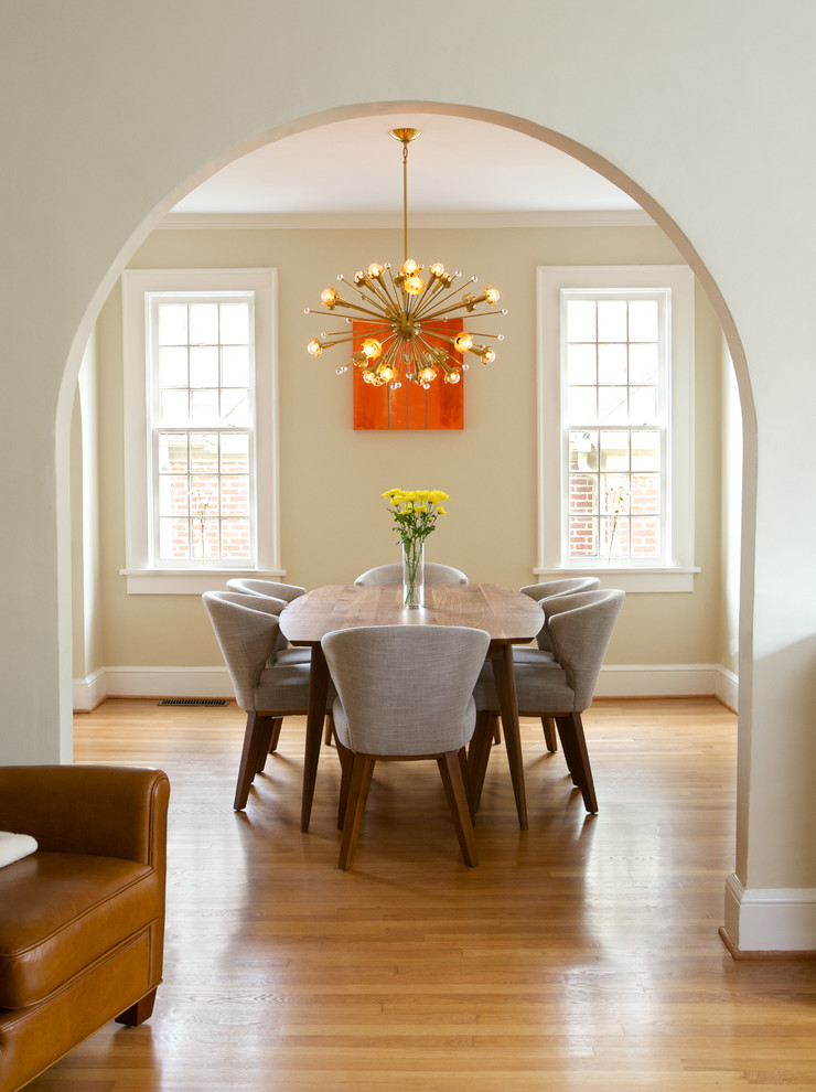 Foto di una sala da pranzo design chiusa con pareti beige e pavimento in legno massello medio
