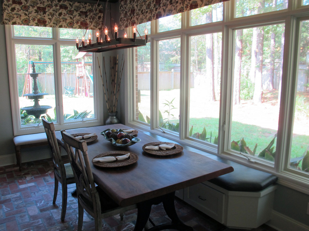 Cette photo montre une salle à manger ouverte sur la cuisine chic de taille moyenne avec un mur gris et un sol en brique.