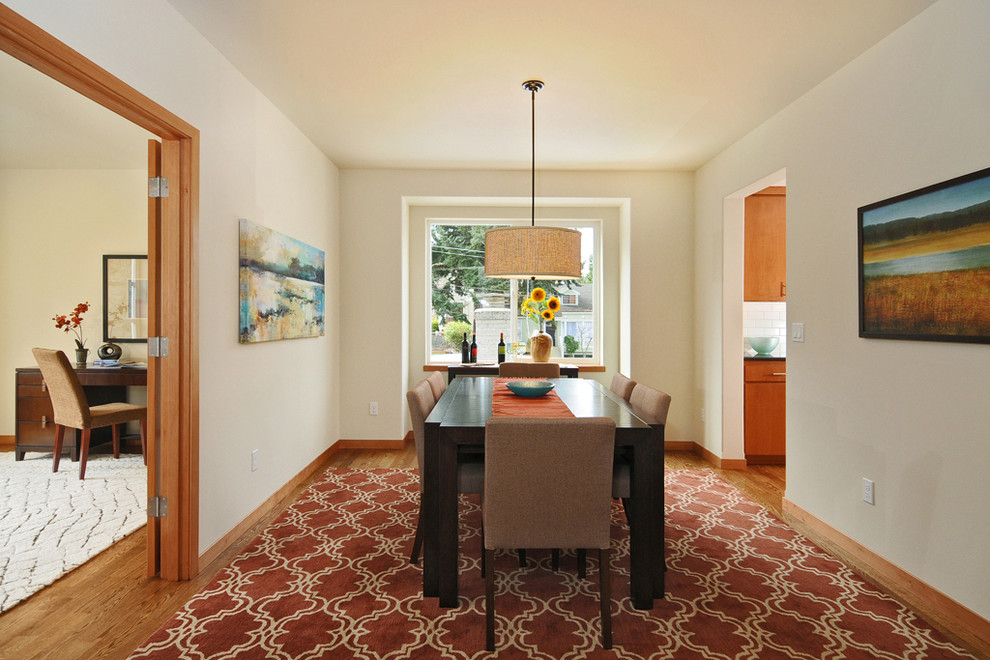 Immagine di una sala da pranzo contemporanea chiusa e di medie dimensioni con pareti bianche e pavimento in legno massello medio