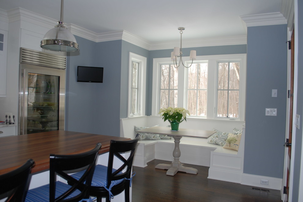 На фото: кухня-столовая в классическом стиле с синими стенами и темным паркетным полом
