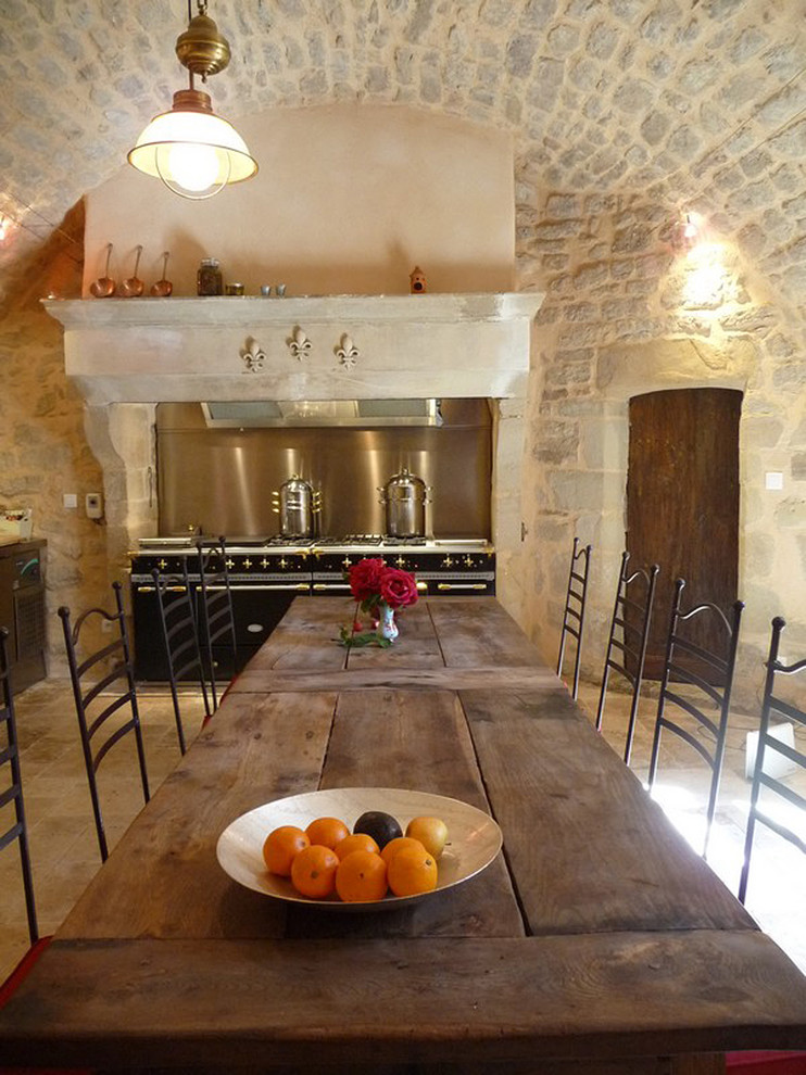Diseño de comedor de cocina mediterráneo grande con suelo de piedra caliza