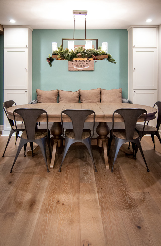 Aménagement d'une salle à manger ouverte sur la cuisine campagne de taille moyenne avec un mur vert et un sol en bois brun.