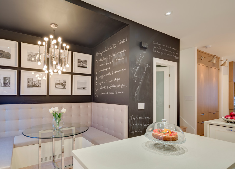 Immagine di una sala da pranzo aperta verso la cucina tradizionale di medie dimensioni con pareti nere e parquet chiaro