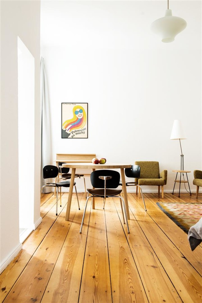 Kleine Retro Wohnküche ohne Kamin mit weißer Wandfarbe und hellem Holzboden in Berlin