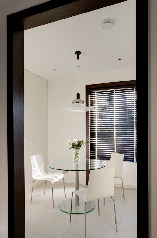 Foto di una piccola sala da pranzo aperta verso la cucina design con pareti bianche, pavimento bianco, pavimento con piastrelle in ceramica e nessun camino