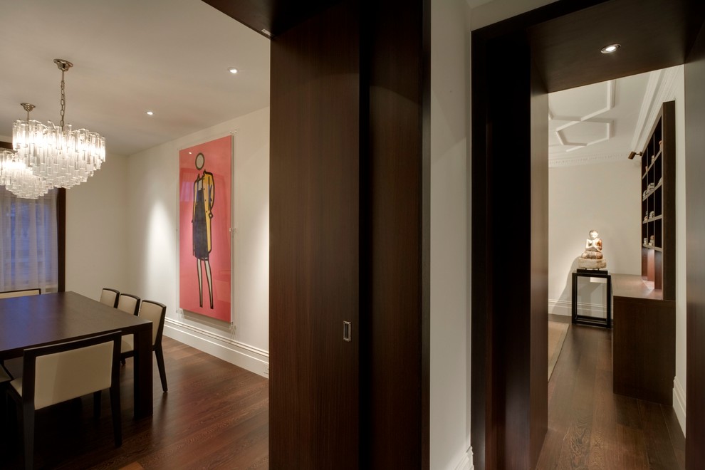 Example of a mid-sized trendy dark wood floor and brown floor enclosed dining room design in London with white walls and no fireplace