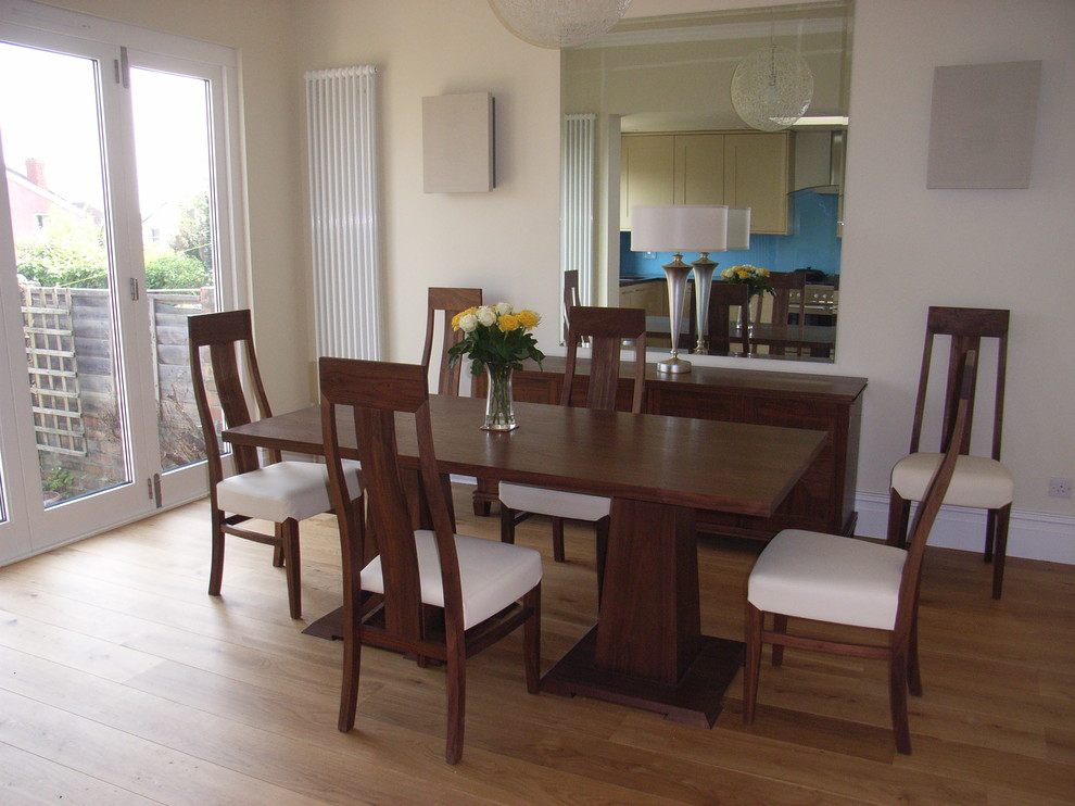 Cette image montre une salle à manger ouverte sur le salon design de taille moyenne avec un mur beige et parquet clair.