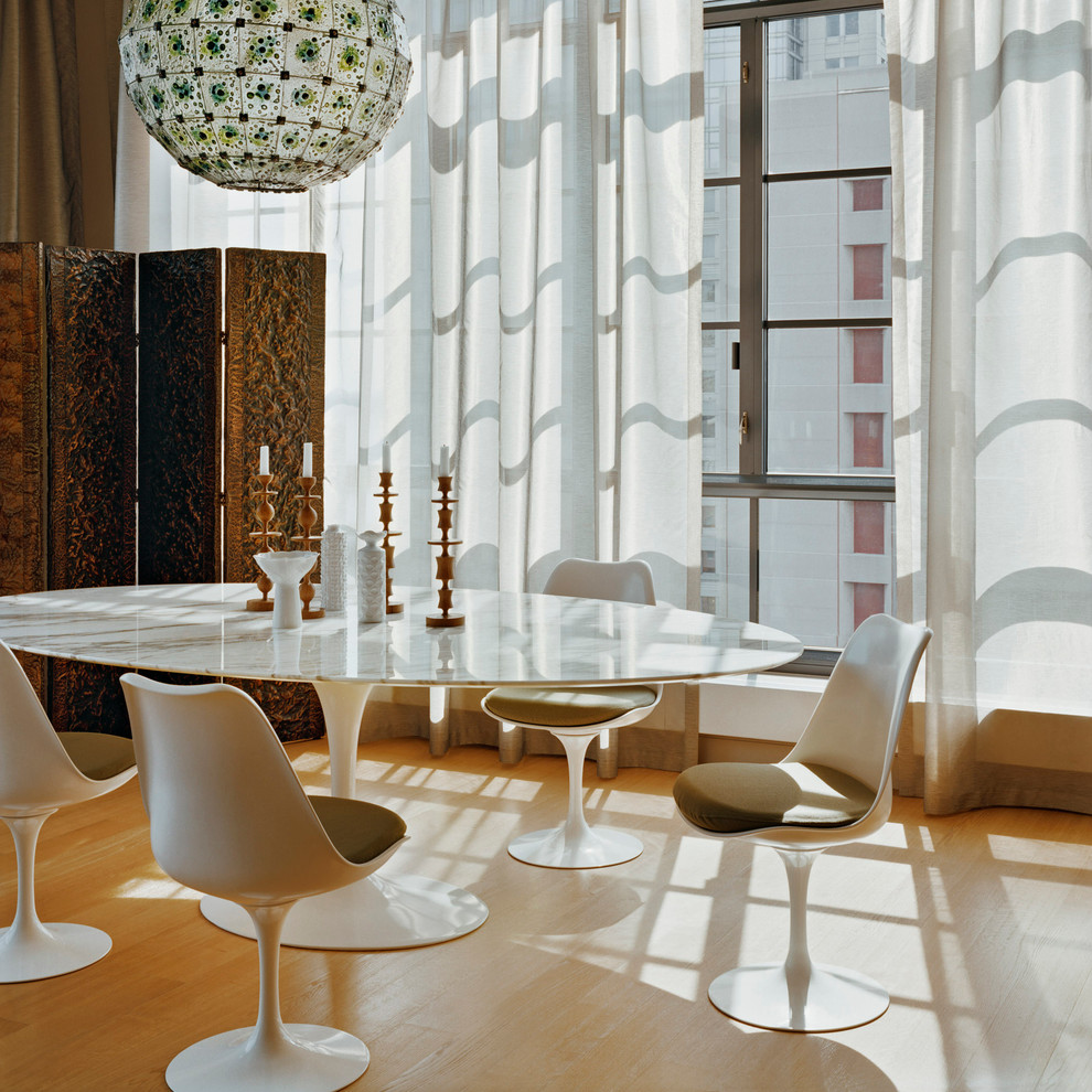 Esempio di una sala da pranzo minimalista con pavimento in legno massello medio