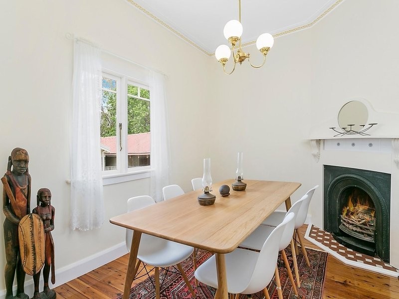 Moderne Wohnküche mit weißer Wandfarbe, braunem Holzboden, Eckkamin und gefliester Kaminumrandung in Sydney
