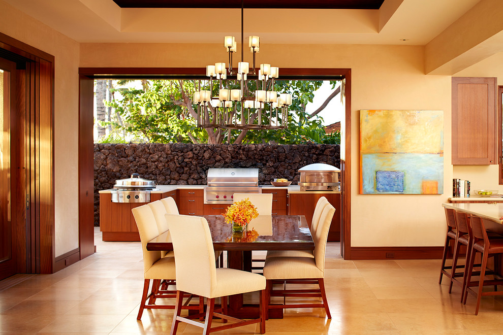 Immagine di una sala da pranzo aperta verso la cucina tropicale con pareti beige e pavimento beige