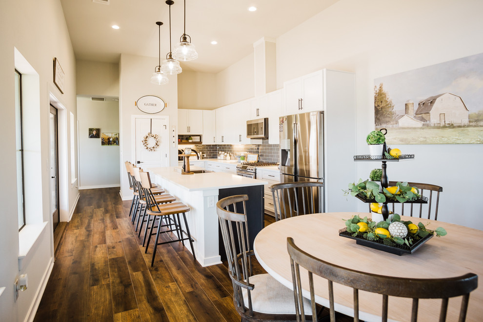 Example of a mid-sized farmhouse medium tone wood floor and brown floor kitchen/dining room combo design in Austin with gray walls