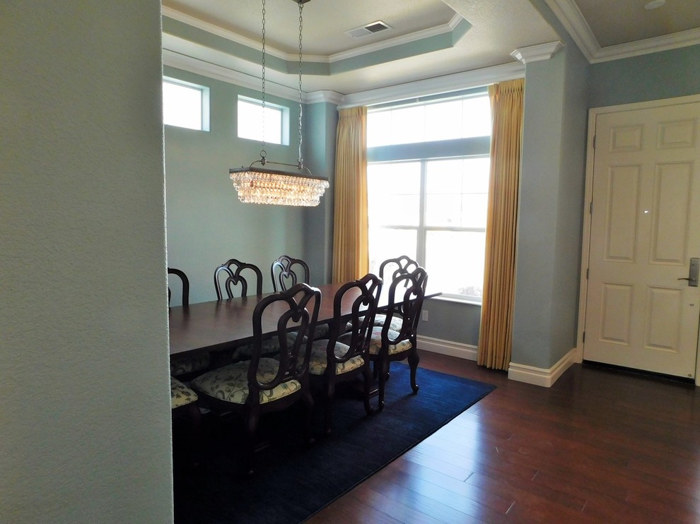 Immagine di una grande sala da pranzo aperta verso il soggiorno tradizionale con pareti blu e parquet chiaro