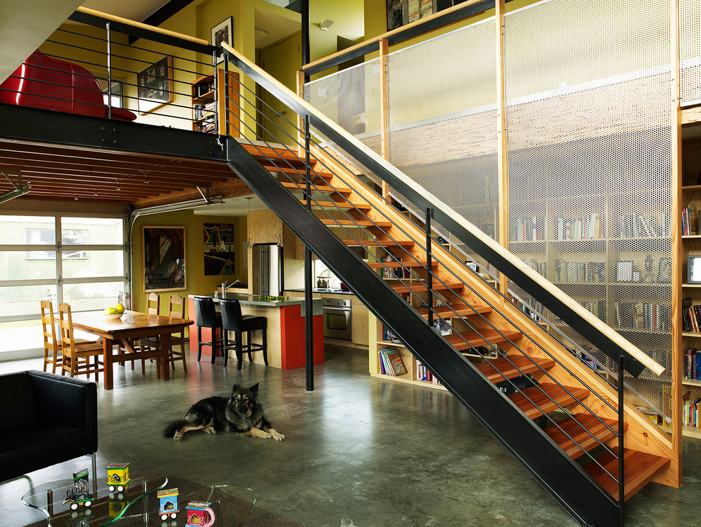 Idee per una piccola sala da pranzo aperta verso il soggiorno industriale con pareti gialle e pavimento in cemento