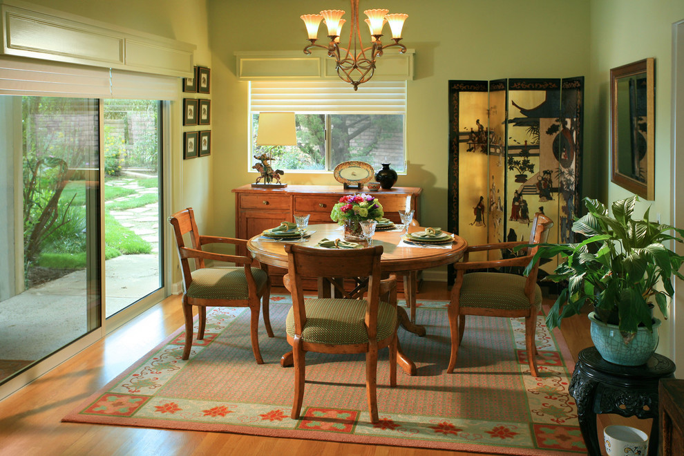 Idées déco pour une petite salle à manger classique avec un mur vert et un sol en bois brun.