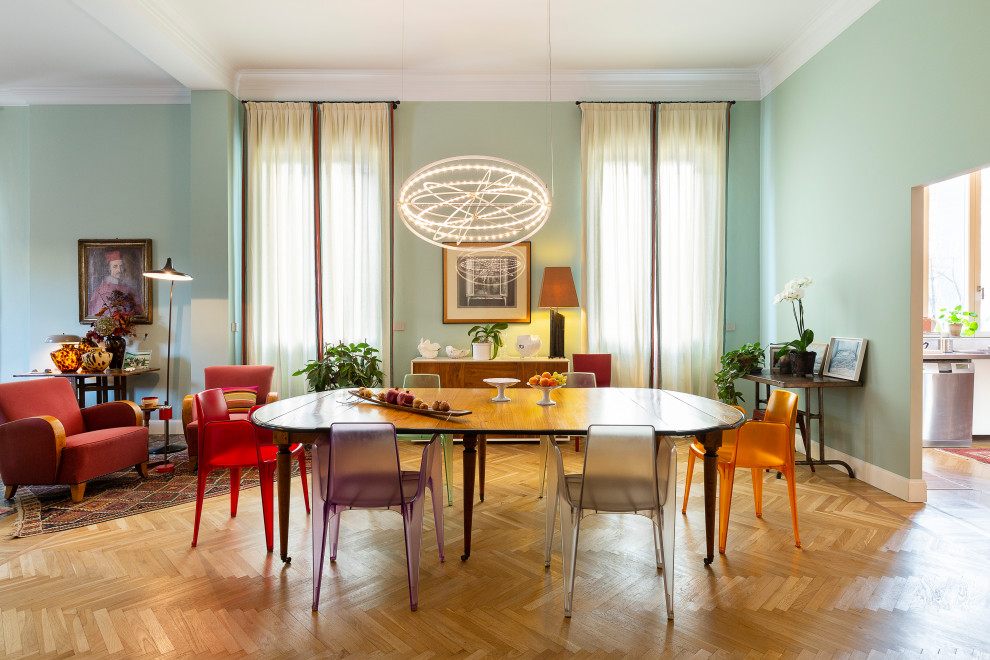 Großes Eklektisches Esszimmer mit grüner Wandfarbe, hellem Holzboden und braunem Boden in Mailand