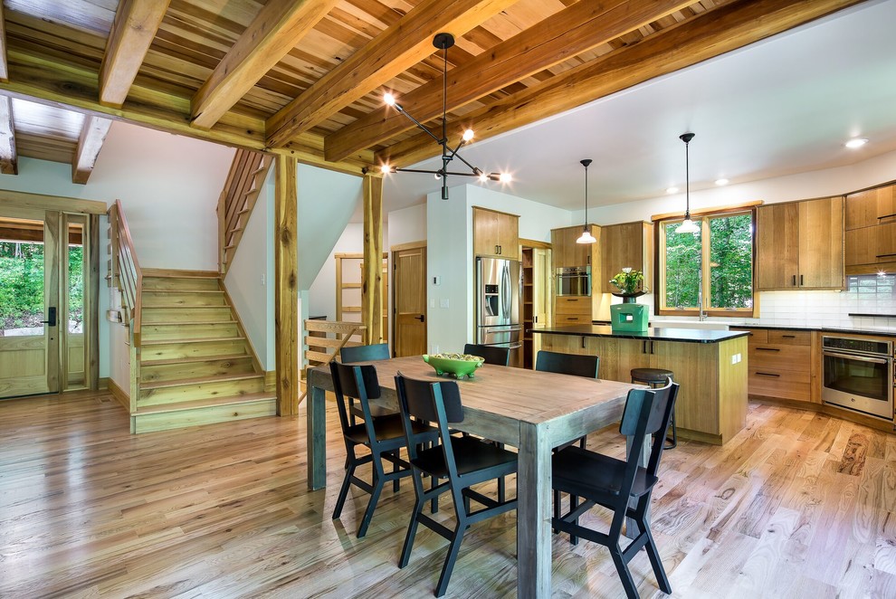Example of a mid-sized trendy light wood floor kitchen/dining room combo design in Other with white walls