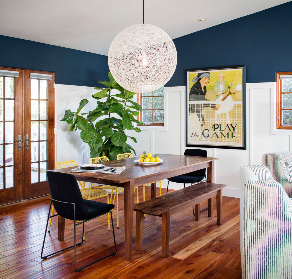 Foto di una sala da pranzo aperta verso il soggiorno stile marinaro di medie dimensioni con pareti blu, pavimento in legno massello medio e nessun camino