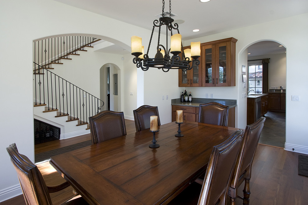 Design ideas for a mediterranean enclosed dining room in San Diego with white walls and dark hardwood flooring.