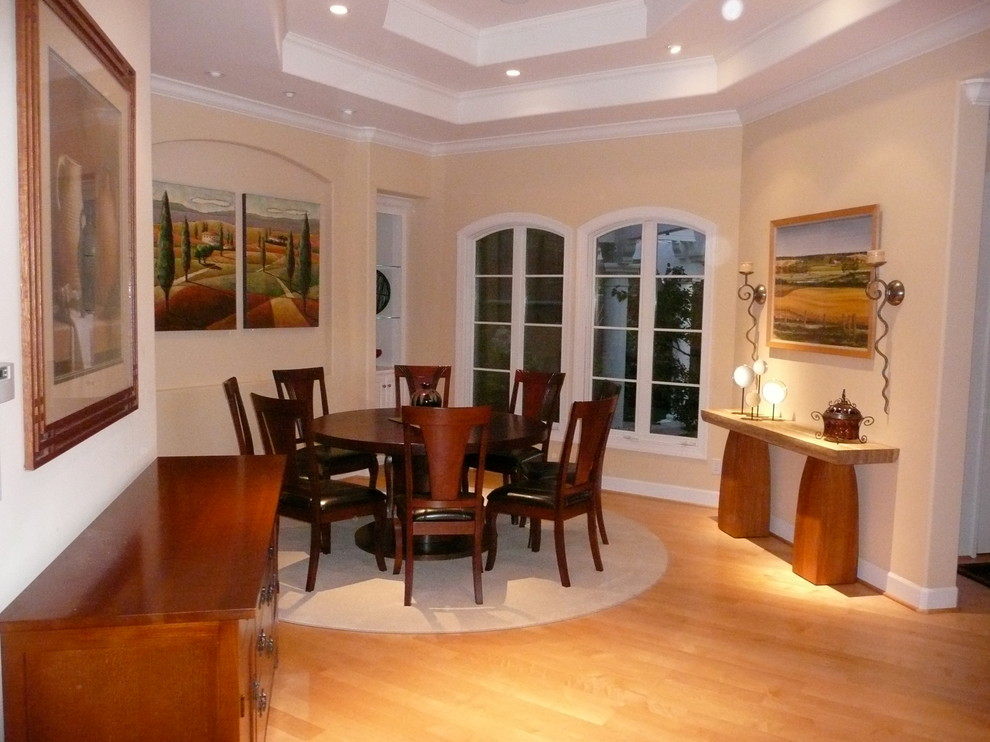 Foto di una grande sala da pranzo classica chiusa con pareti beige e pavimento in legno massello medio