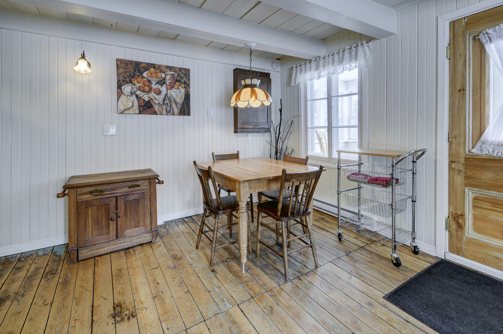 Rustik inredning av ett litet kök med matplats, med vita väggar och ljust trägolv