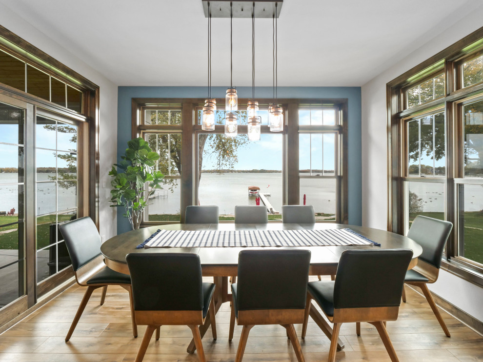 Idée de décoration pour une grande salle à manger ouverte sur la cuisine chalet avec un mur bleu, un sol en vinyl, un sol marron et un plafond voûté.