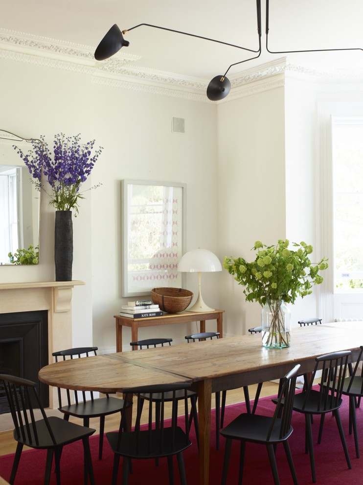 Immagine di una grande sala da pranzo aperta verso la cucina moderna con pareti beige, parquet scuro, camino classico, cornice del camino in pietra e pavimento marrone