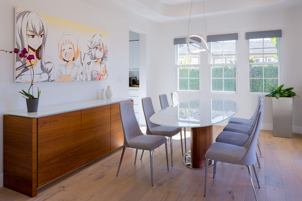 This is an example of a small contemporary enclosed dining room in Orange County with white walls, light hardwood flooring and no fireplace.