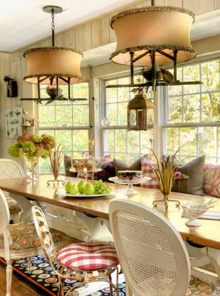 Foto di una sala da pranzo aperta verso la cucina country di medie dimensioni con pareti bianche, pavimento in legno massello medio e nessun camino