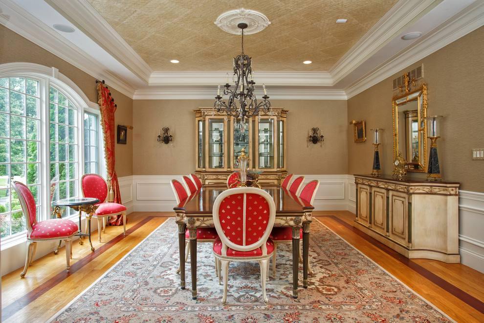 Cette image montre une grande salle à manger ouverte sur la cuisine traditionnelle avec un mur beige, parquet clair et aucune cheminée.