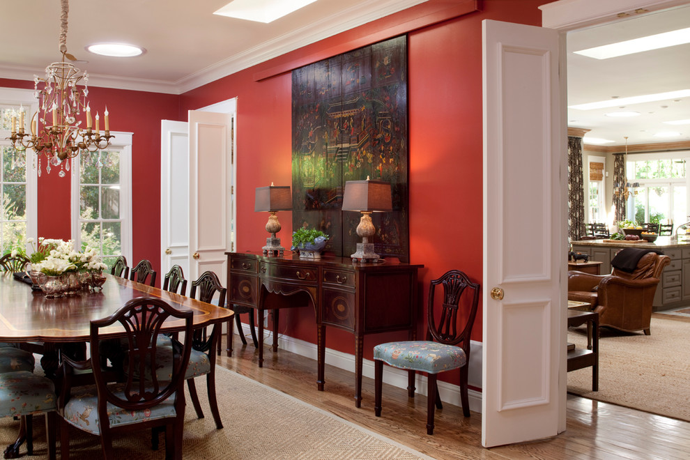 Ejemplo de comedor tradicional de tamaño medio cerrado con paredes rojas y suelo de madera en tonos medios
