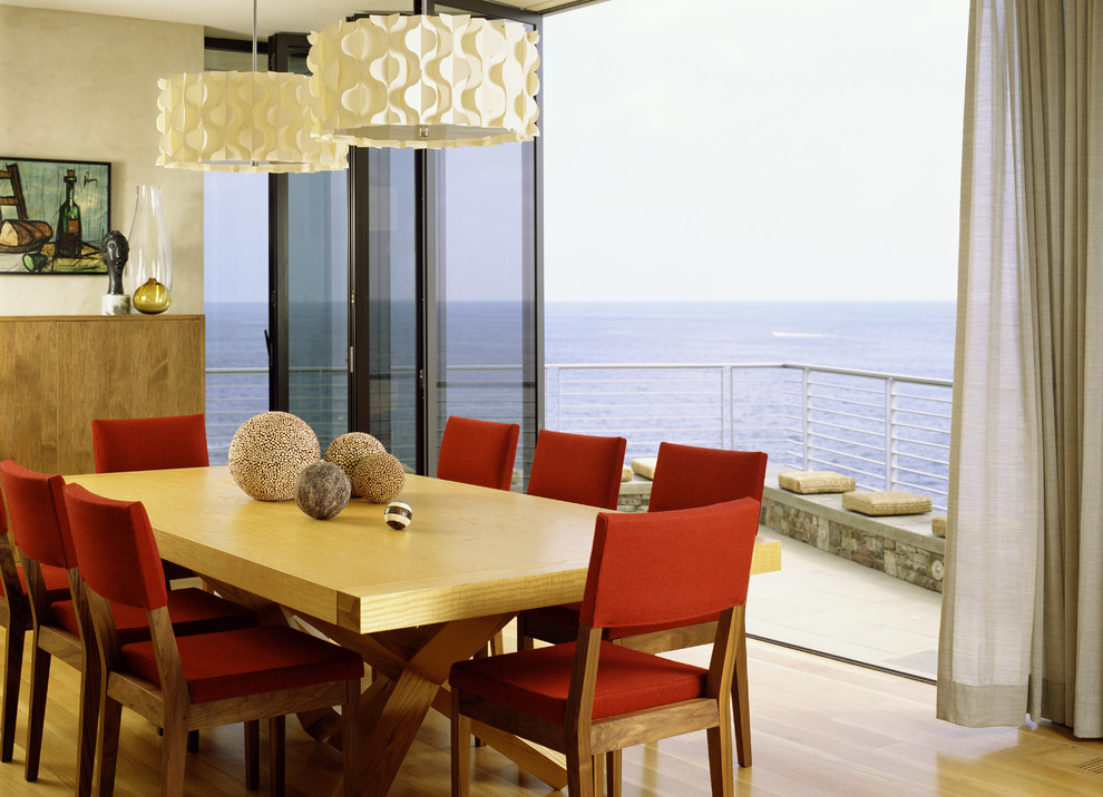 Modelo de comedor minimalista con paredes beige, suelo de madera en tonos medios y cortinas