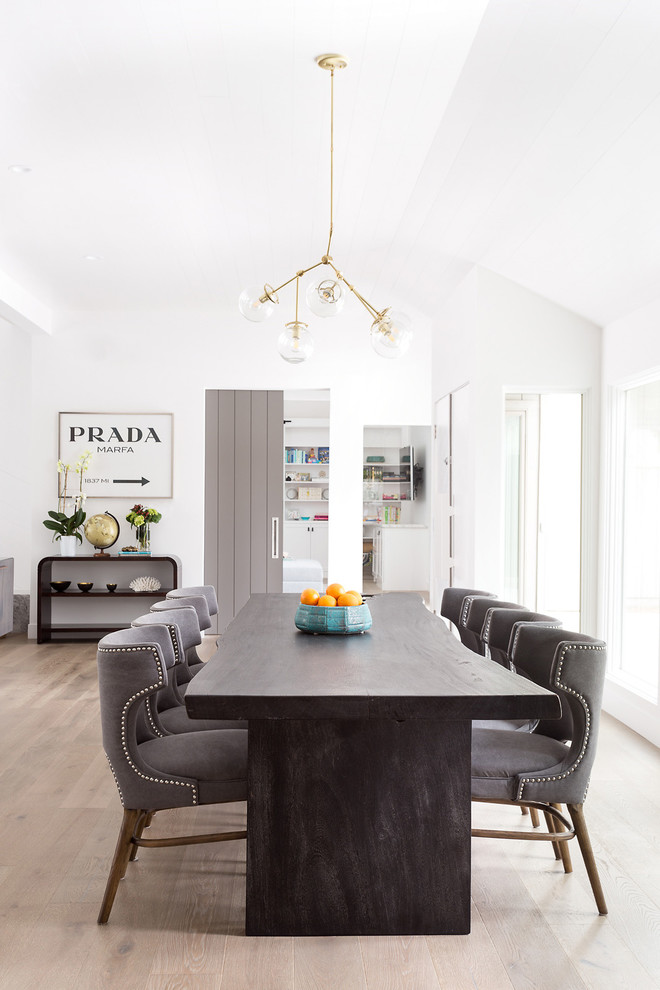 Photo of a contemporary dining room in Los Angeles with white walls and light hardwood flooring.