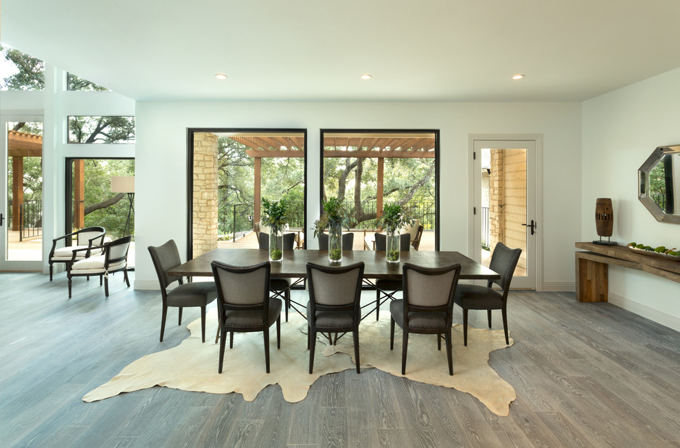 Immagine di una grande sala da pranzo aperta verso la cucina contemporanea con parquet chiaro e pareti bianche