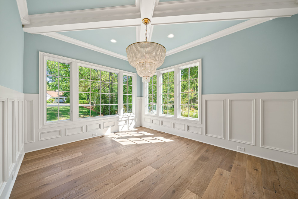 Esempio di una grande sala da pranzo classica chiusa con pareti blu, pavimento in legno massello medio, pavimento marrone, soffitto a cassettoni e boiserie