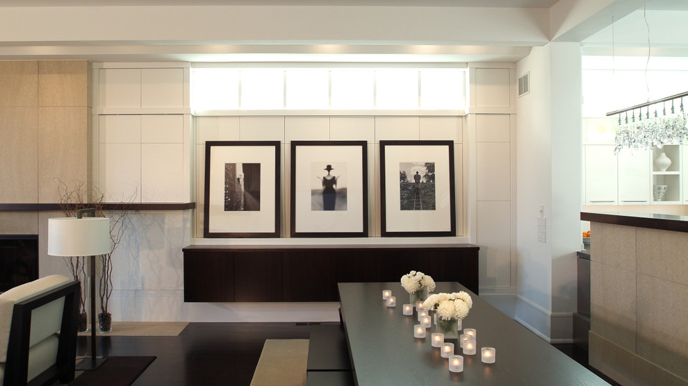 Aménagement d'une salle à manger ouverte sur le salon contemporaine avec un mur blanc et éclairage.
