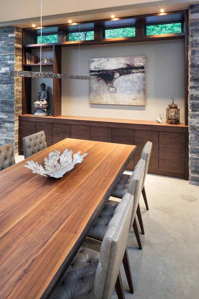 Cette photo montre une petite salle à manger ouverte sur le salon moderne avec un mur beige et sol en béton ciré.
