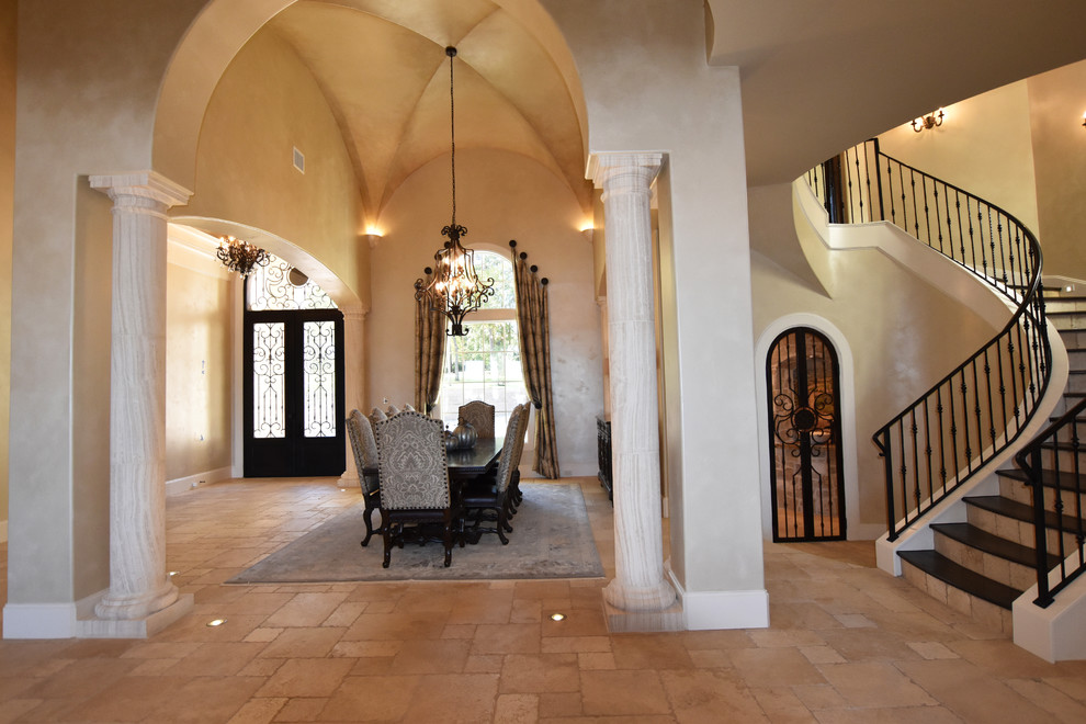 This is an example of an expansive mediterranean dining room in Houston with travertine flooring.