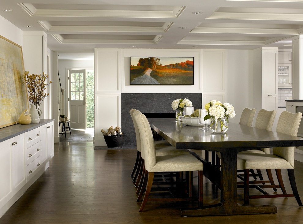 Esempio di una sala da pranzo tradizionale con pareti bianche, parquet scuro, camino classico e pavimento marrone